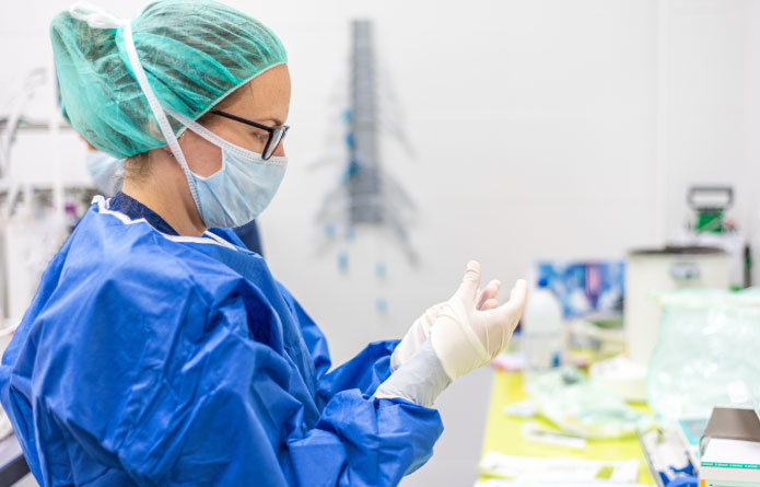 Doctora colocándose guantes de seguridad