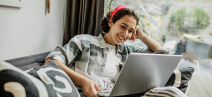 Joven sonriendo mirando computador